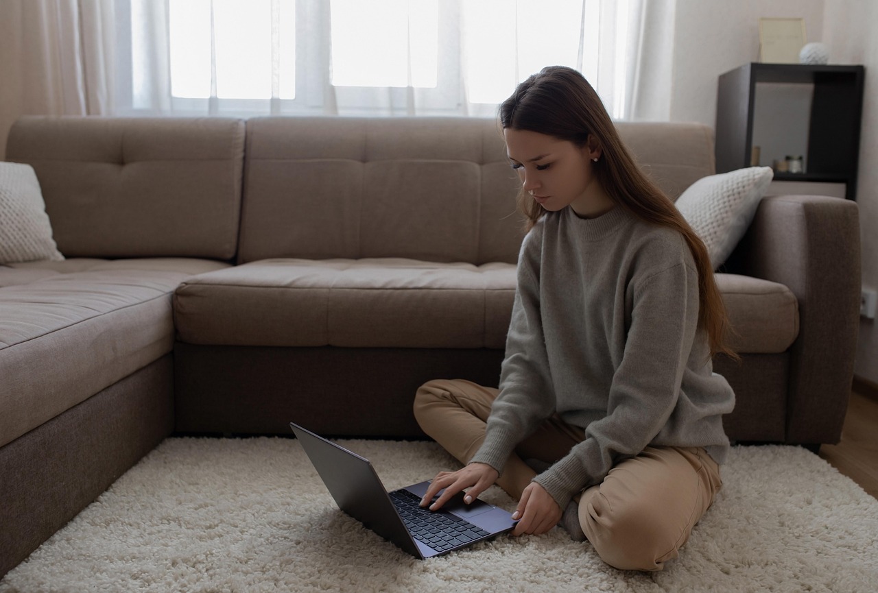 Woman teleworking with a laptop on the sofa