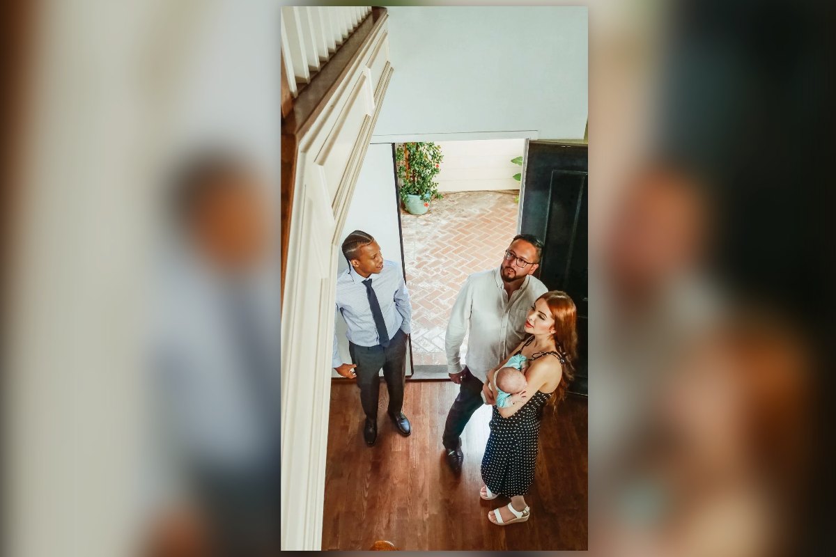 A young family with a baby walking into a home