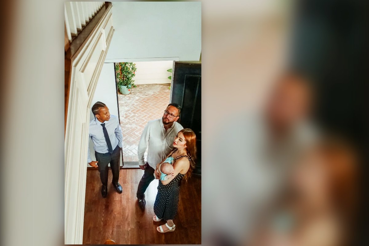 A young family with a baby walking into a home