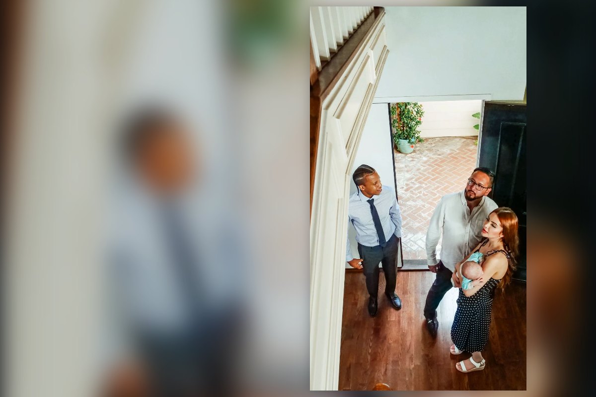 A young family with a baby walking into a home