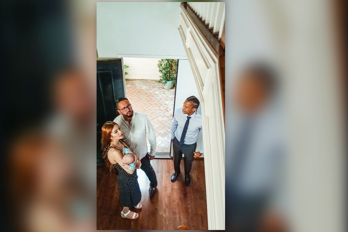 A young family with a baby walking into a home