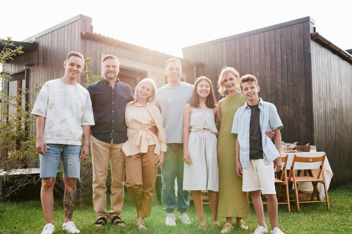 An extended family standing together in front of their house