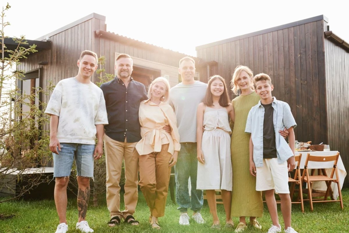 An extended family standing together in front of their house