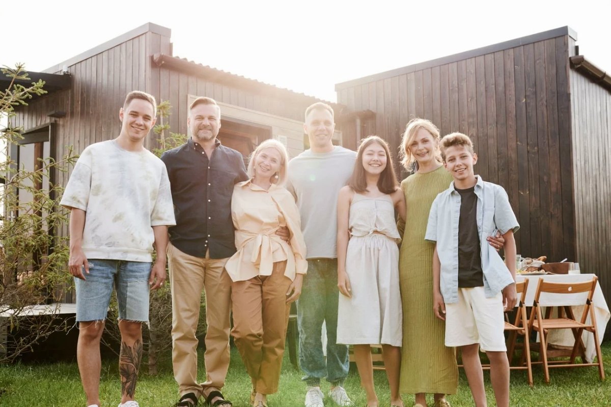 An extended family standing together in front of their house