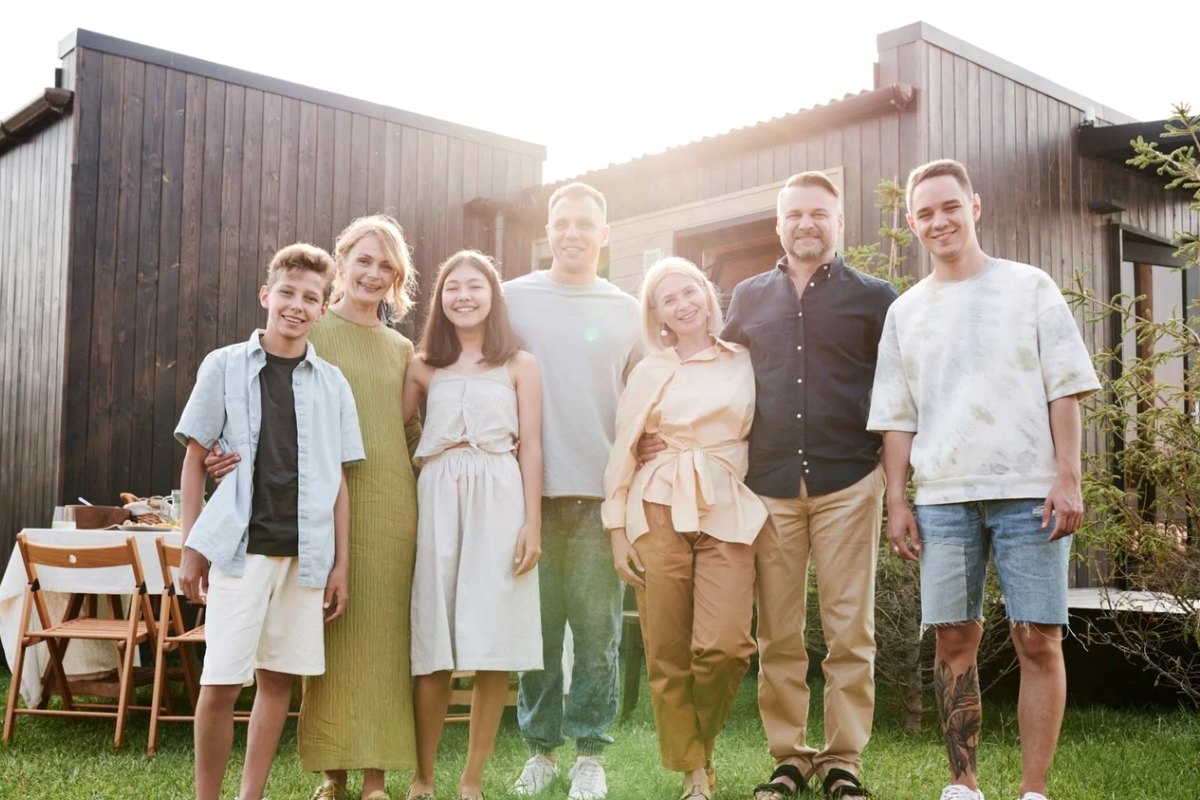 An extended family standing together in front of their house