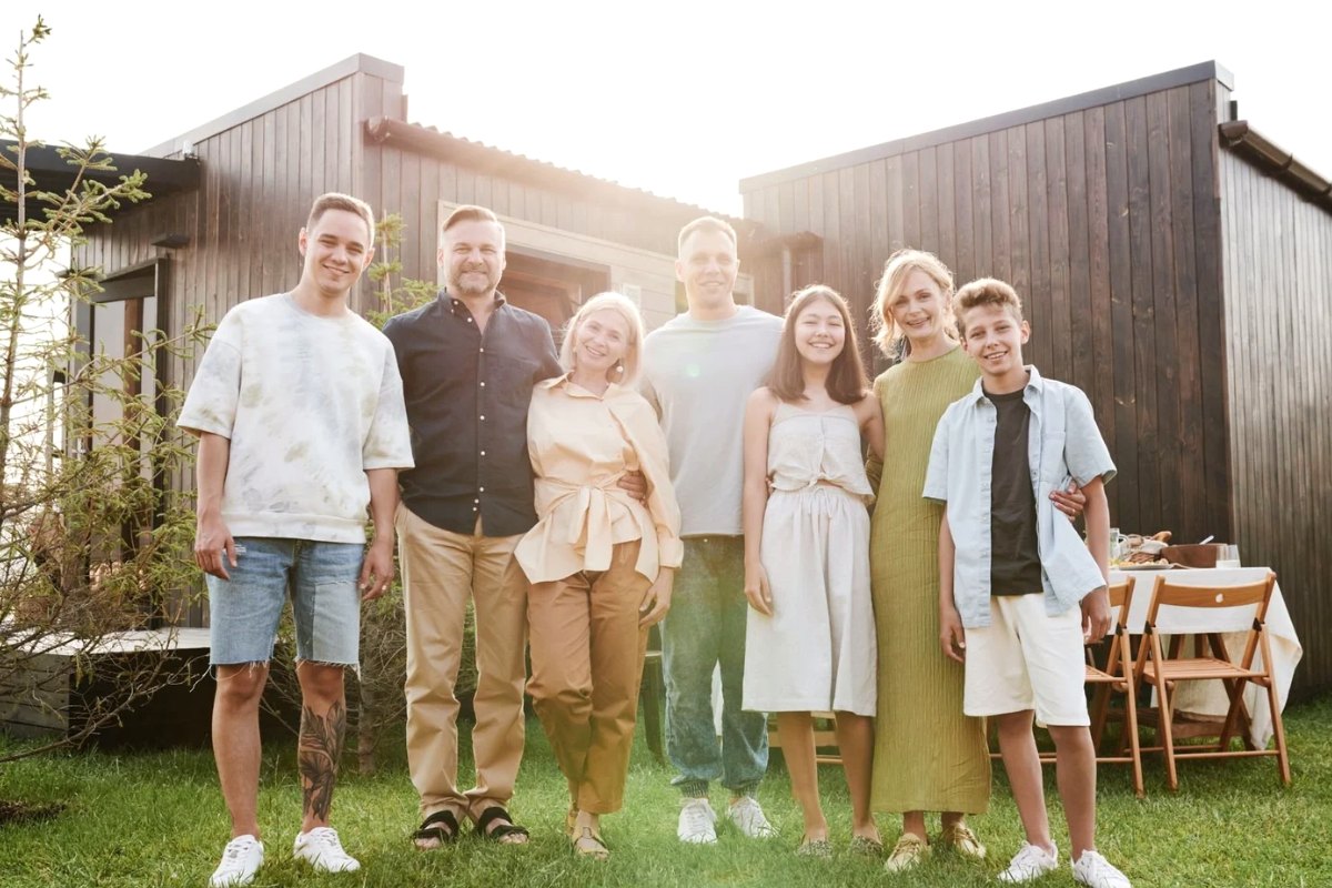 An extended family standing together in front of their house