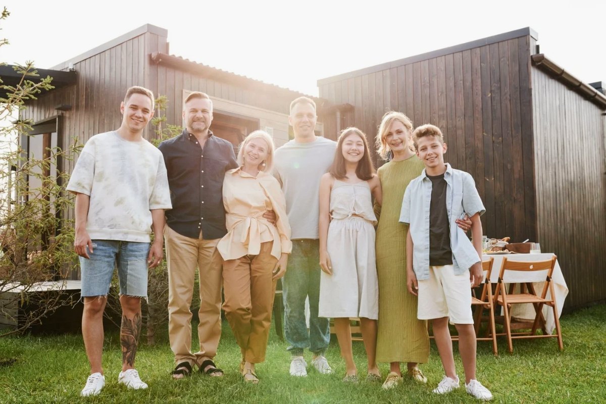 An extended family standing together in front of their house