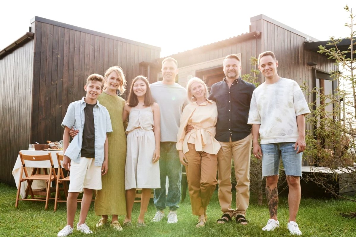 An extended family standing together in front of their house
