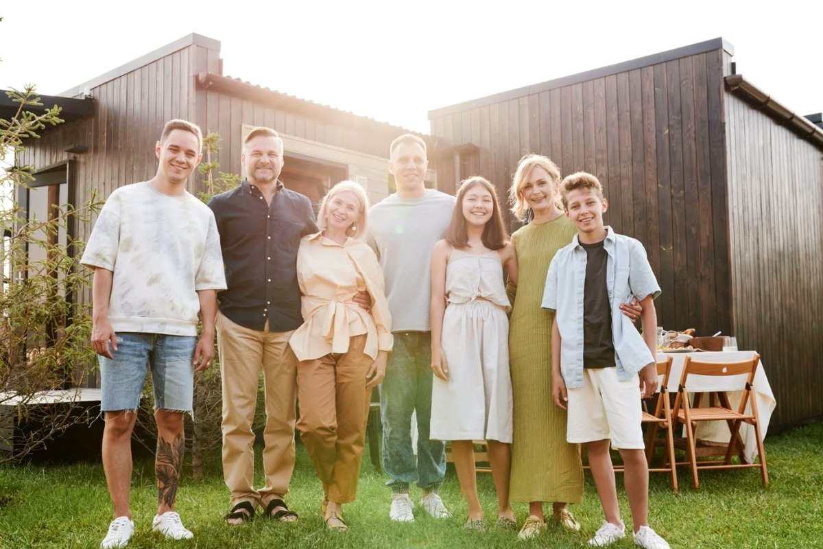 An extended family standing together in front of their house