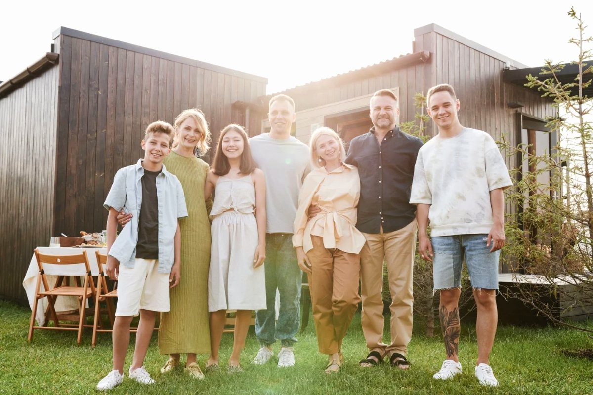 An extended family standing together in front of their house