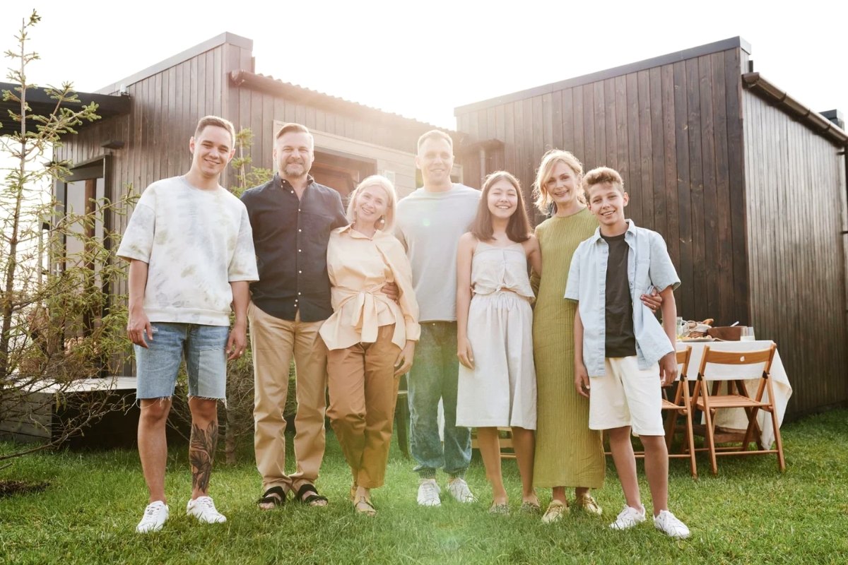 An extended family standing together in front of their house