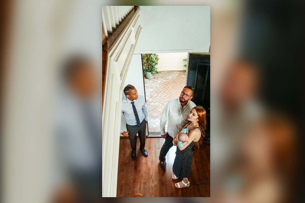 A young family with a baby walking into a home