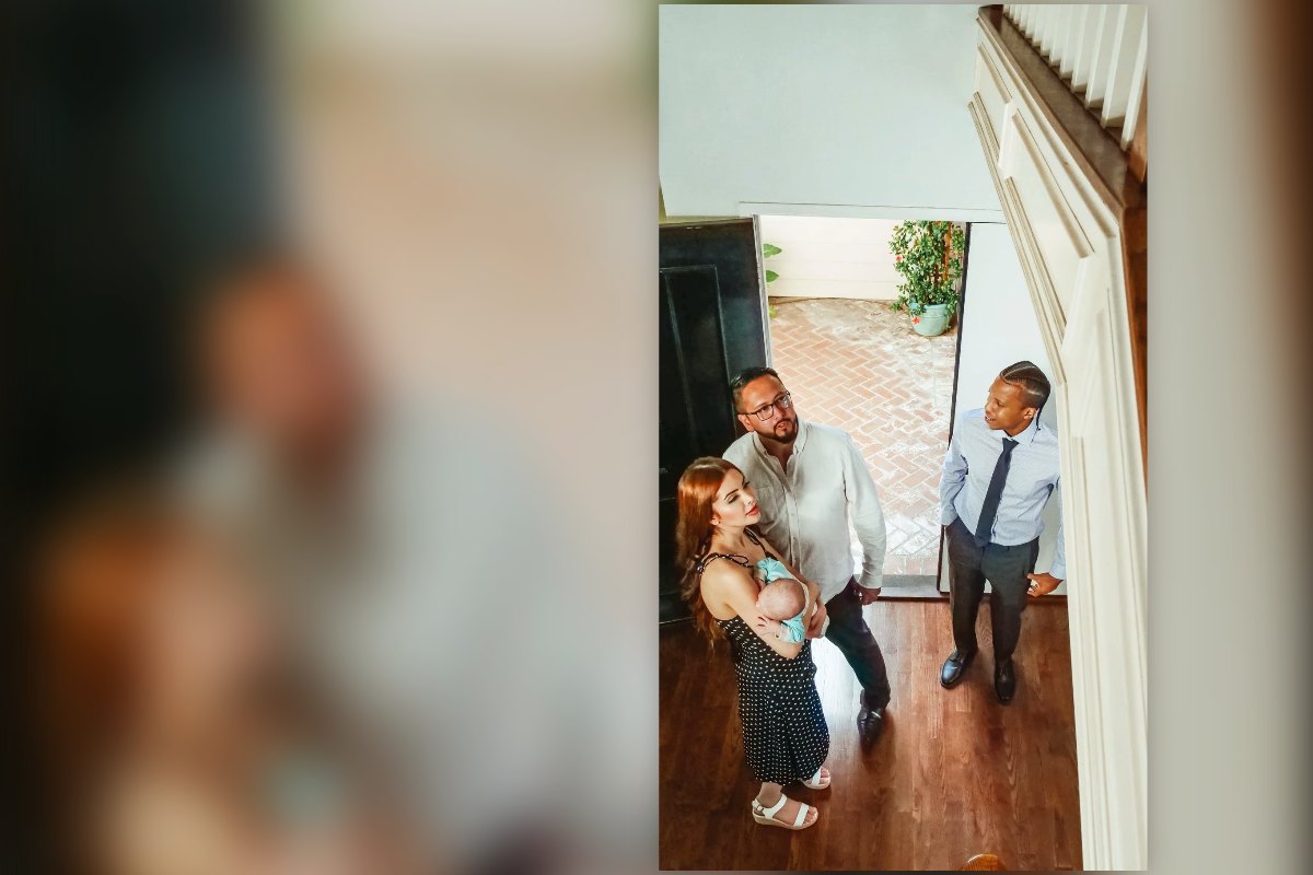 A young family with a baby walking into a home