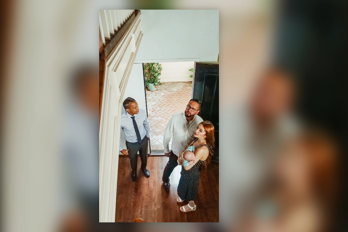 A young family with a baby walking into a home