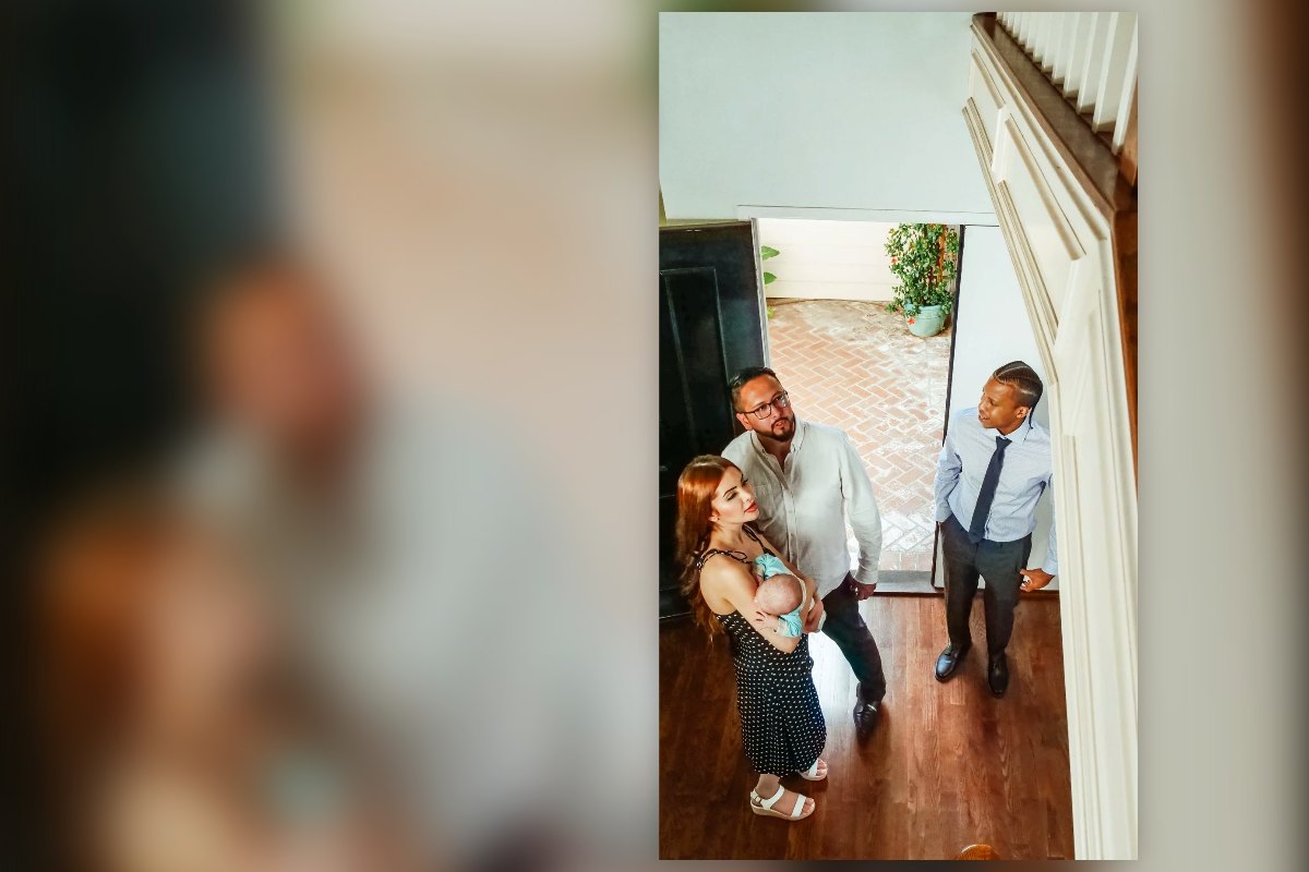 A young family with a baby walking into a home