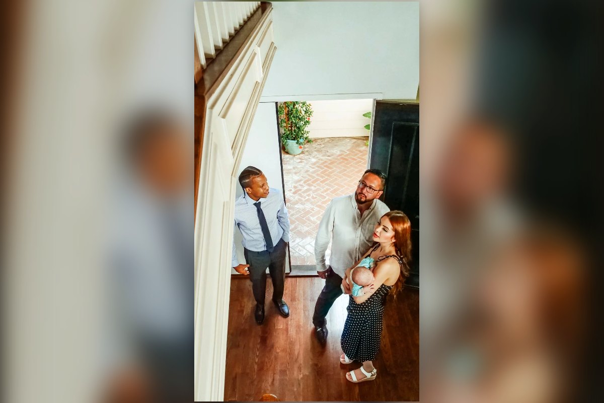 A young family with a baby walking into a home